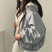 Giacca invernale donna grigia, imbottita, con cappuccio in pelliccia sintetica, stile casual, moda autunno inverno, abbigliamento caldo e confortevole.
