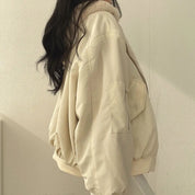 Giacca beige oversize invernale con colletto in pelliccia sintetica, tasca laterale, indossata da donna. Stile casual, moda autunno-inverno.