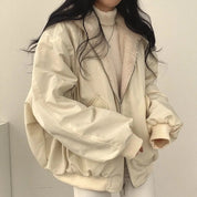 Giacca oversize beige con zip, colletto in pelliccia sintetica, indossata su maglione a collo alto. Moda donna autunno inverno, stile casual chic.