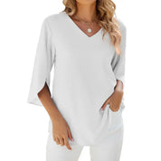 Maglietta bianca da donna con scollo a V, maniche a tre quarti, indossata da modella. Moda casual elegante, perfetta per look estivi e primaverili.