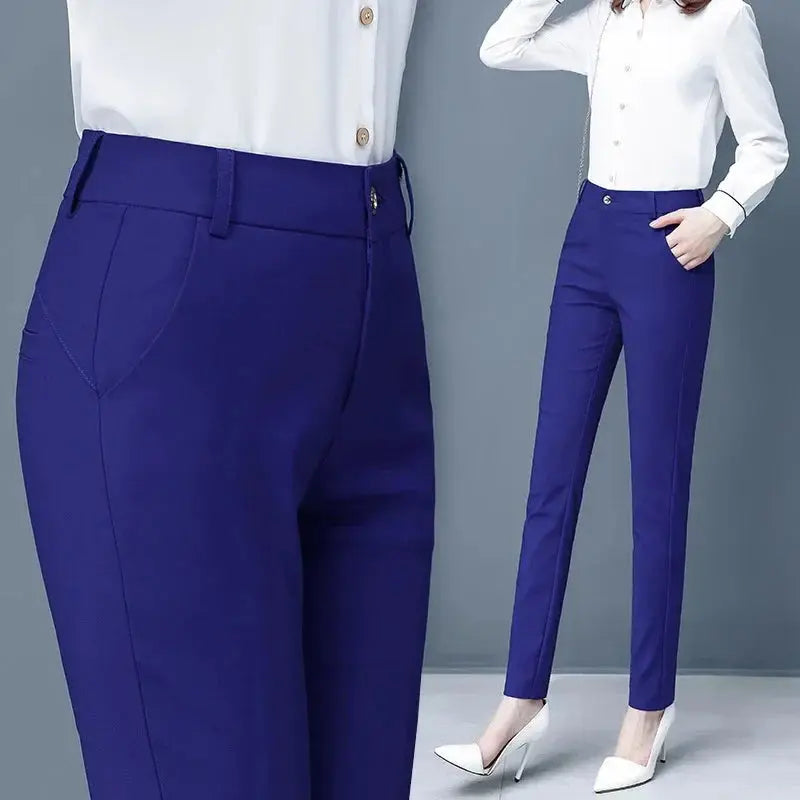 Pantaloni donna blu eleganti, taglio slim, abbinati a camicia bianca. Moda femminile, abbigliamento formale, stile ufficio.