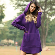 Donna con felpa viola con cappuccio, tasca frontale, in un parco. Moda casual autunnale, abbigliamento comodo, stile urbano.