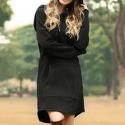 Donna con abito felpa nero con cappuccio, tasca frontale, in un parco. Moda casual autunnale, abbigliamento comodo e trendy.