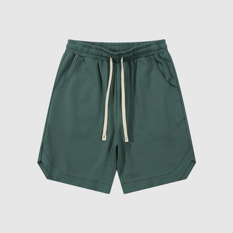 Pantaloncini sportivi verdi da uomo con tasche laterali e coulisse, stile casual, tessuto leggero, ideali per attività all'aperto e tempo libero.