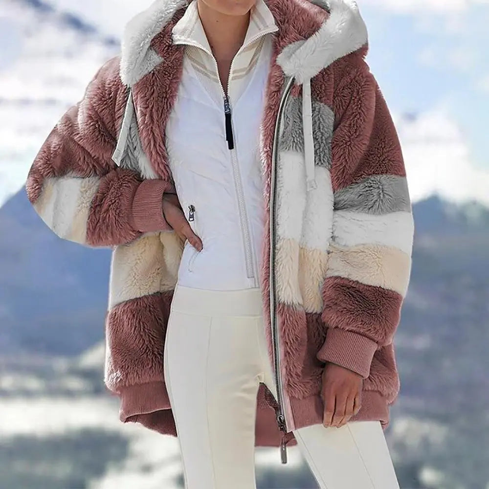 Giacca invernale donna a righe multicolore, cappuccio, tessuto pelliccia sintetica, chiusura zip, stile casual, montagna sullo sfondo.