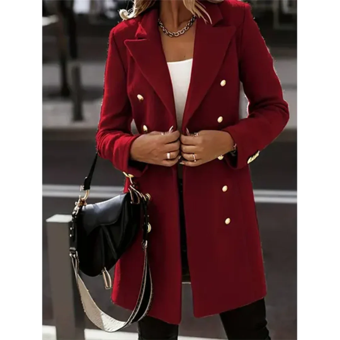 Cappotto rosso elegante da donna con bottoni dorati, indossato su top bianco. Accessoriato con borsa nera a tracolla. Moda autunnale chic.