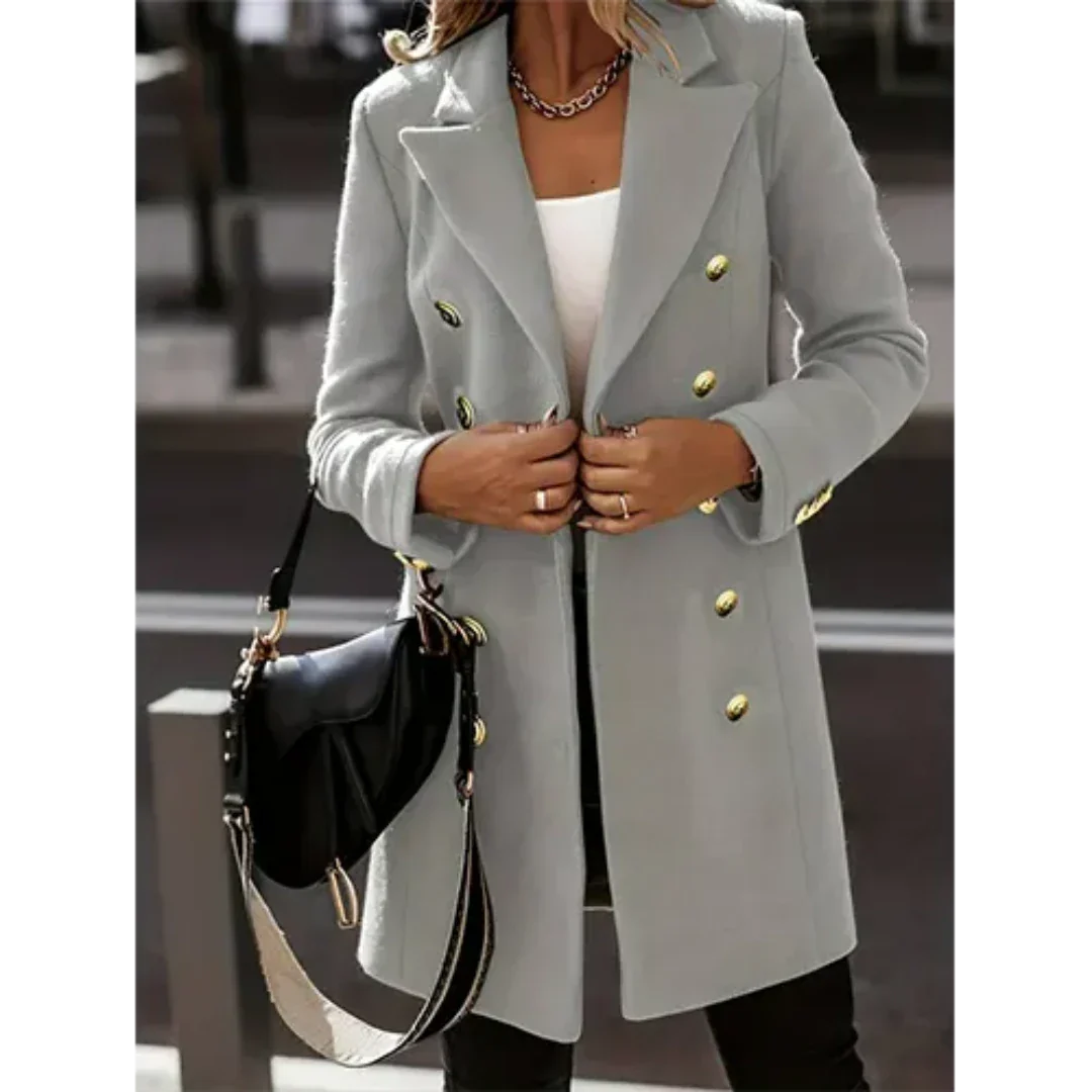 Cappotto donna elegante grigio con bottoni dorati, abbinato a borsa nera. Moda autunnale, stile sofisticato, abbigliamento femminile di tendenza.