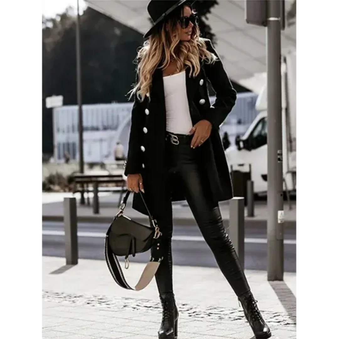 Donna alla moda con cappotto nero, pantaloni in pelle, stivali e borsa elegante. Look autunnale chic, perfetto per lo street style urbano.