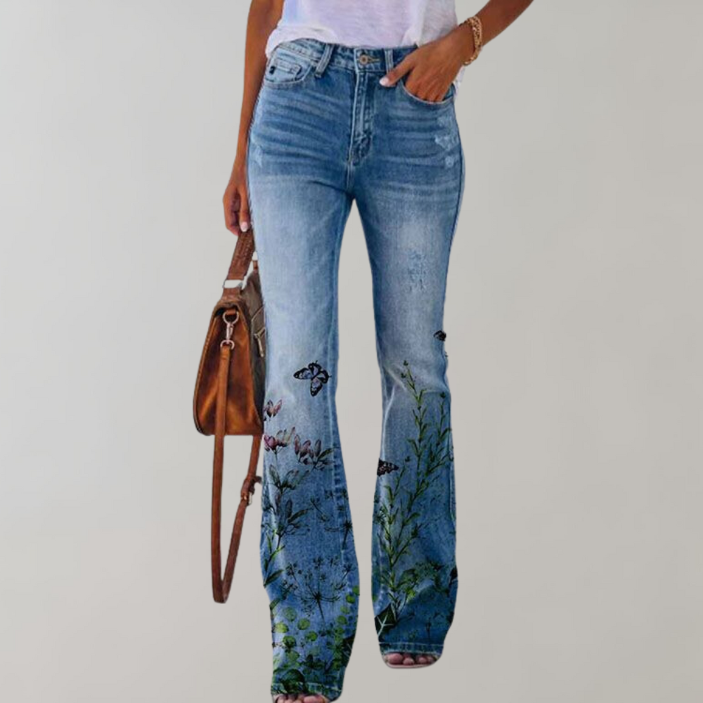 Jeans a zampa di elefante da donna con ricami floreali e farfalle, abbinati a una borsa marrone. Stile casual, moda primavera-estate.