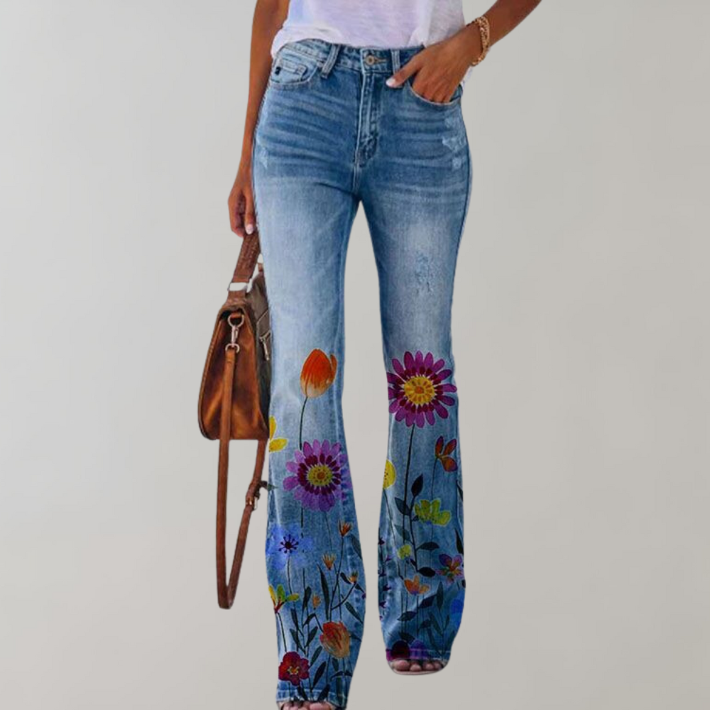 Jeans a zampa da donna con stampa floreale colorata, abbinati a una borsa marrone. Stile casual, perfetti per la moda primaverile ed estiva.