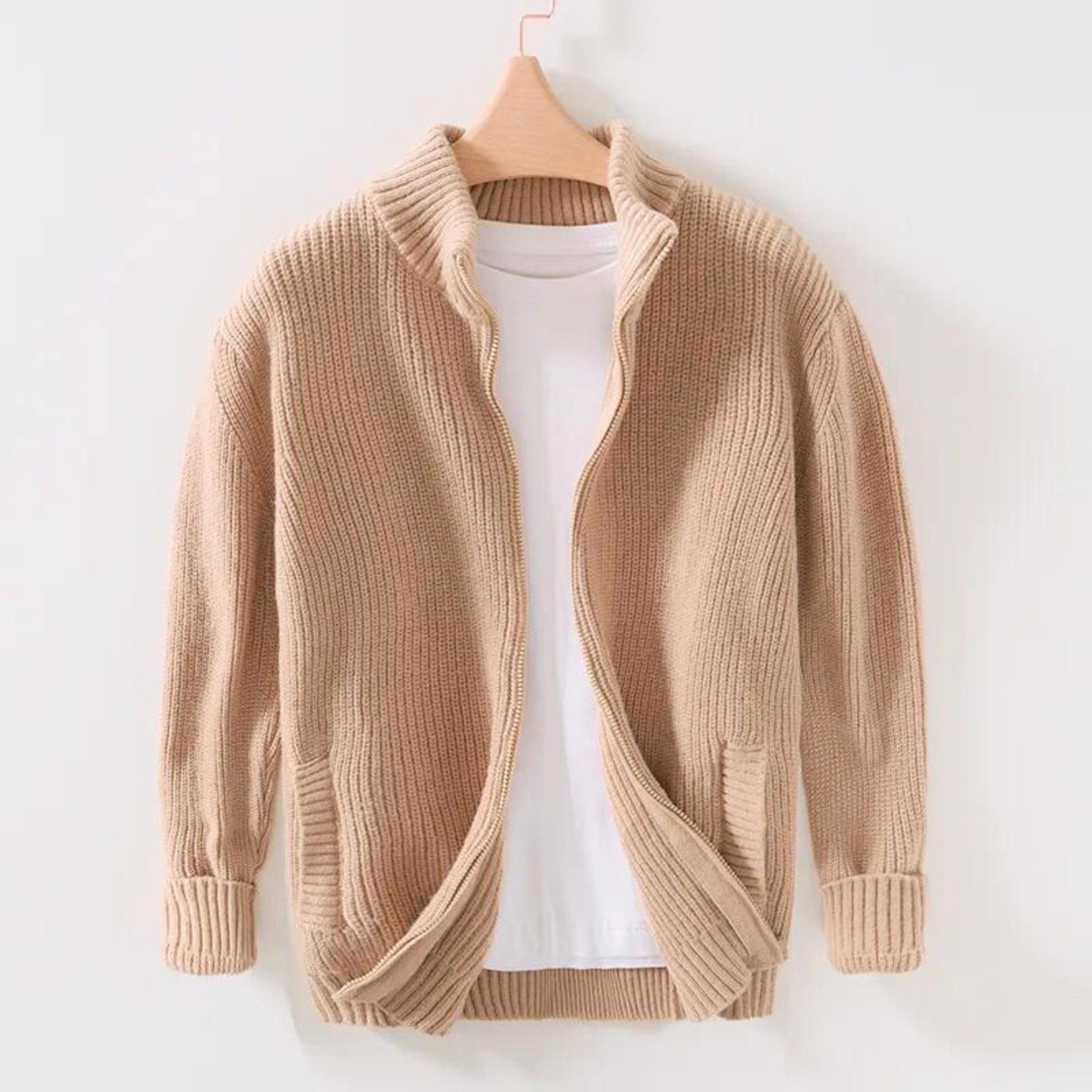 Cardigan beige in maglia a coste con zip, collo alto e tasche, su gruccia. Maglione casual da uomo, moda autunno inverno, abbigliamento caldo.