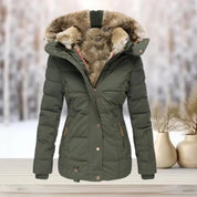 Giacca invernale verde con cappuccio foderato in pelliccia sintetica, chiusura a zip, tasche laterali, su sfondo innevato. Perfetta per il freddo.