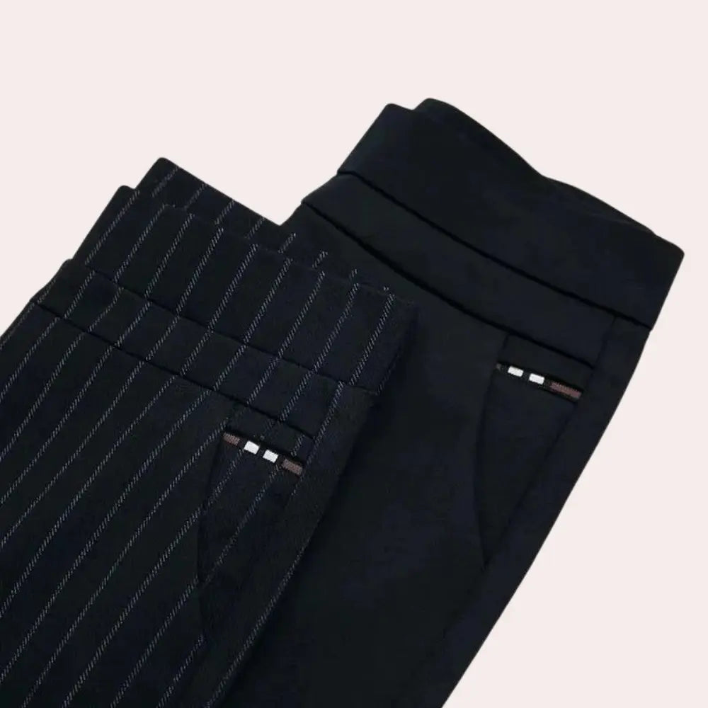 Pantaloni eleganti da uomo, uno a righe sottili e uno nero, piegati su sfondo chiaro. Moda maschile, abbigliamento formale, pantaloni classici.
