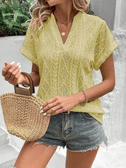 Donna con top giallo traforato, shorts di jeans e borsa di paglia. Moda estiva casual, abbigliamento femminile trendy, look fresco e leggero.