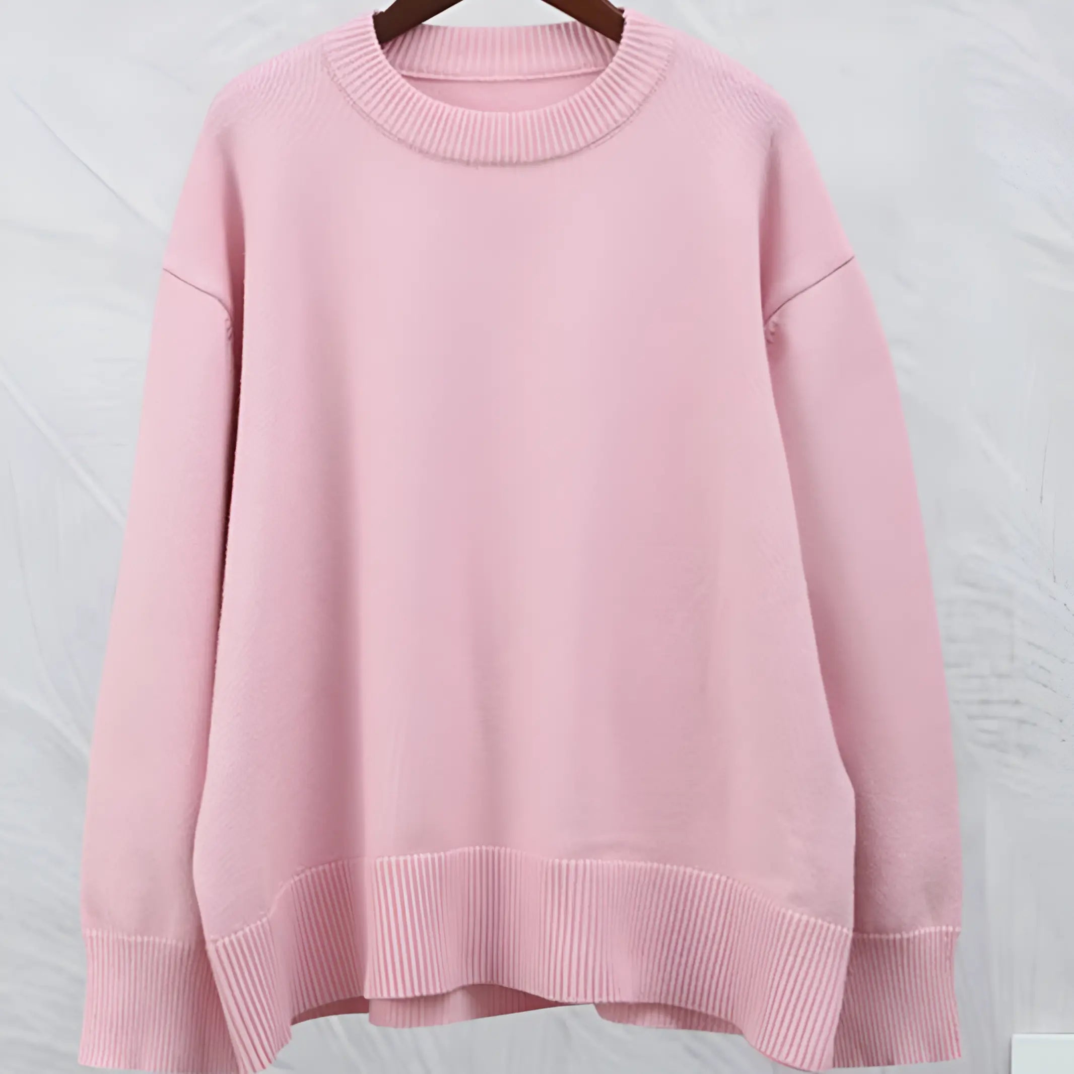 Maglione oversize rosa pastello in cotone, design minimalista, maniche lunghe, scollo rotondo, ideale per moda casual e abbigliamento autunnale.