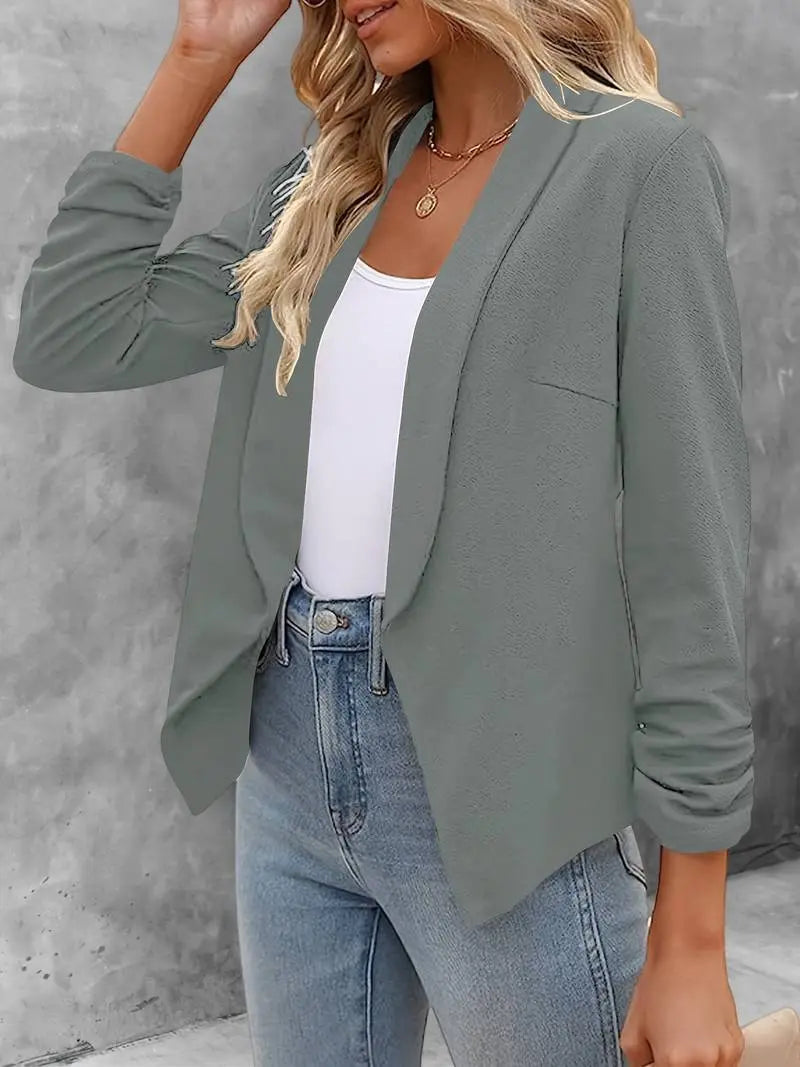 Giacca blazer donna grigia, elegante e casual, abbinata a top bianco e jeans. Moda femminile autunnale, outfit versatile per ufficio e tempo libero.
