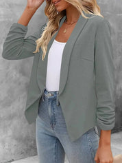 Giacca blazer donna grigia, elegante e casual, abbinata a top bianco e jeans. Moda femminile autunnale, outfit versatile per ufficio e tempo libero.