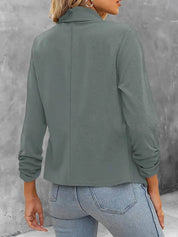 Giacca donna verde salvia, maniche lunghe, collo alto, tessuto morbido. Moda casual autunnale, abbinata a jeans chiari.