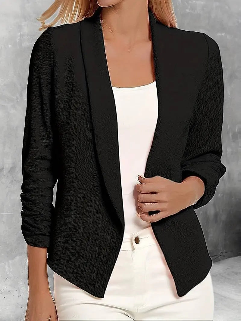 Giacca blazer donna nera elegante, maniche lunghe, abbinata a top bianco e pantaloni chiari. Moda femminile, abbigliamento formale chic.