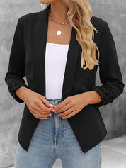 Giacca nera elegante da donna, abbinata a top bianco e jeans. Moda casual chic, perfetta per ufficio o uscite serali.