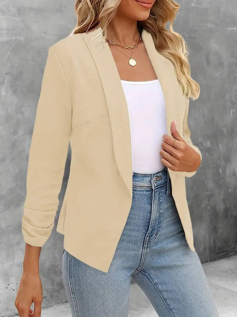 Giacca beige elegante da donna, abbinata a top bianco e jeans. Moda casual chic, ideale per ufficio o eventi formali. Stile moderno e versatile.