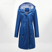 Giacca impermeabile blu da donna con cappuccio, chiusura a zip, tasche frontali e fodera a righe. Elegante e funzionale per pioggia e vento.