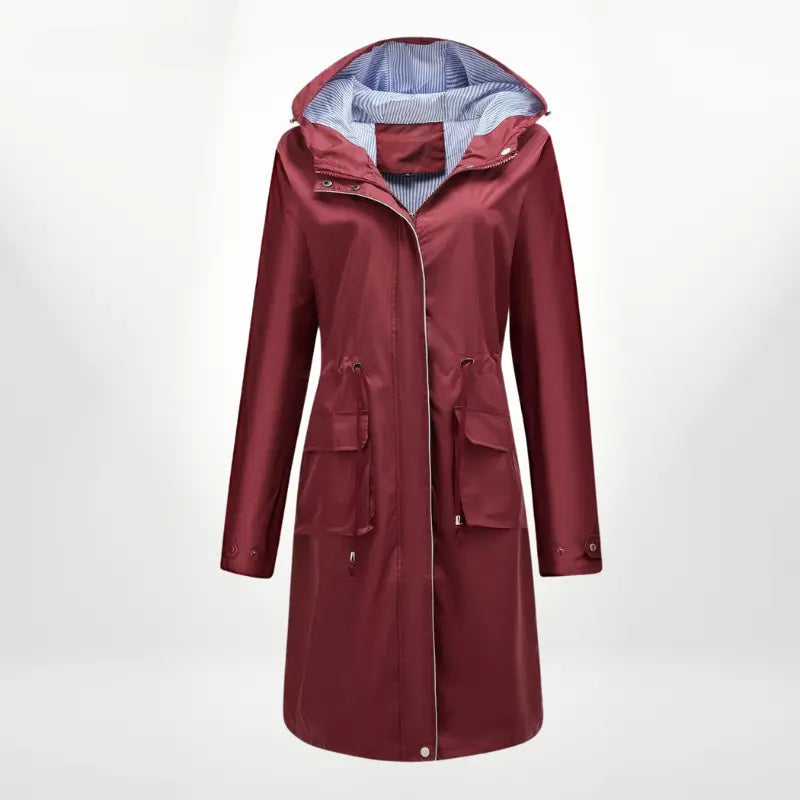 Cappotto impermeabile donna rosso bordeaux con cappuccio, tasche frontali e fodera a righe. Elegante e pratico per pioggia e moda autunnale.