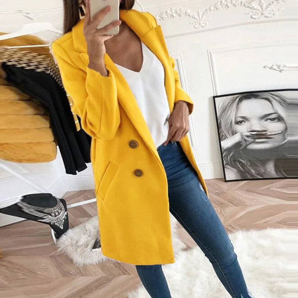 Cappotto giallo elegante da donna, doppio petto, abbinato a jeans aderenti e top bianco, moda autunnale, stile casual chic.