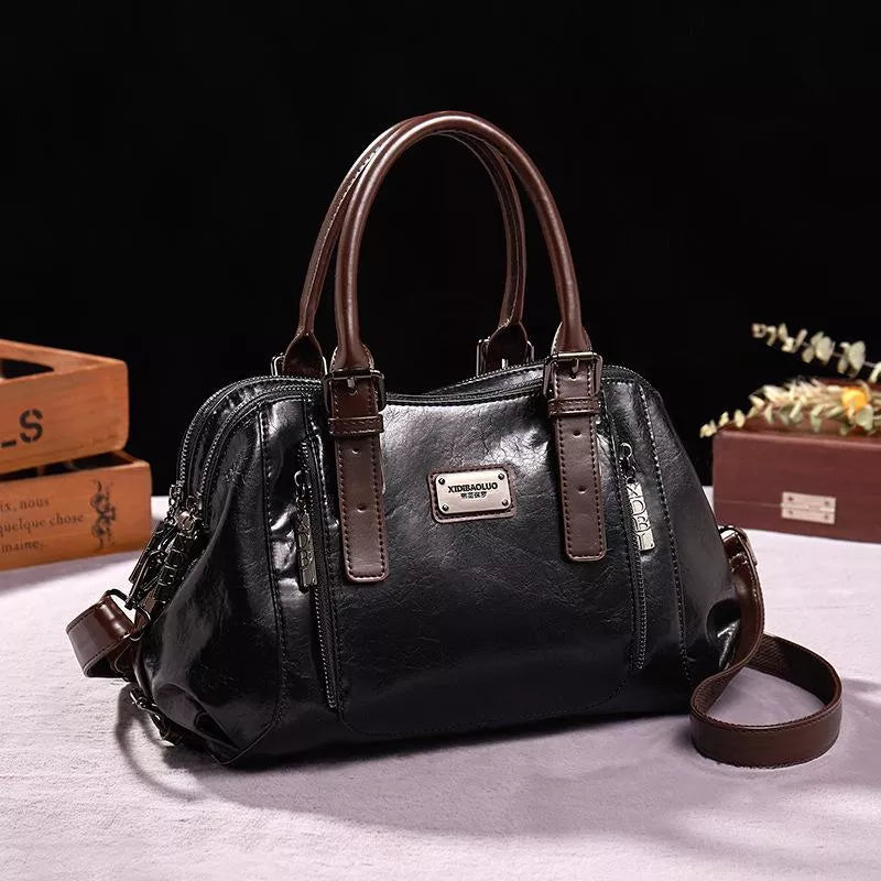 Borsa a mano in pelle nera con manici marroni, design elegante, chiusura a zip, ideale per moda donna, accessorio di tendenza.