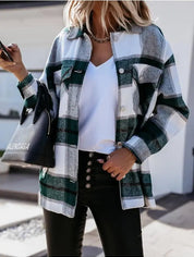 Donna con camicia a quadri verde e bianca, borsa nera Balenciaga, pantaloni neri. Moda autunnale casual chic. Shopping urbano.