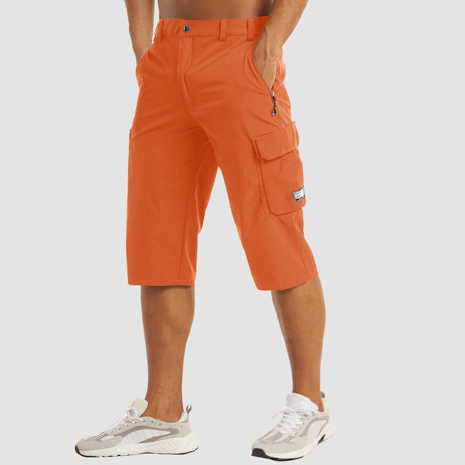 Pantaloncini cargo arancioni da uomo, tasche multiple, lunghezza al ginocchio, stile casual, perfetti per l'estate. Indossati con sneakers bianche.