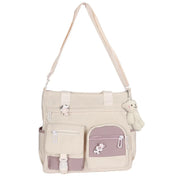 Borsa a tracolla beige con tasche multiple e ciondolo orsetto, design casual, ideale per scuola o lavoro. Accessorio moda donna pratico e trendy.