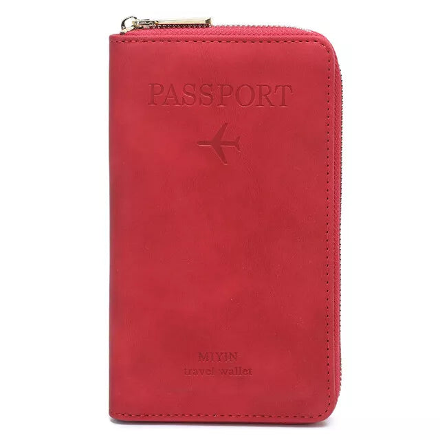 Portafoglio da viaggio rosso in pelle con cerniera, design per passaporto, logo aereo inciso, ideale per viaggiatori, accessorio elegante e funzionale.