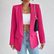 Giacca blazer donna fucsia, elegante e moderna, abbinata a top bianco e jeans. Accessorio borsa a catena dorata. Moda femminile trendy.