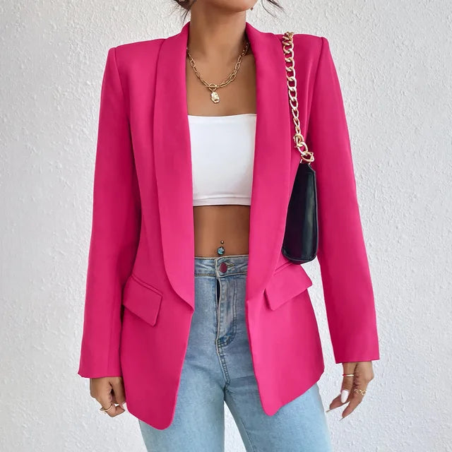 Giacca blazer donna fucsia, elegante e moderna, abbinata a top bianco e jeans. Accessorio borsa a catena dorata. Moda femminile trendy.