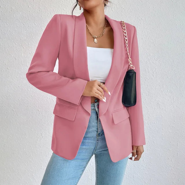 Giacca blazer rosa da donna, elegante e moderna, abbinata a top bianco e jeans. Accessorio: borsa nera a tracolla con catena dorata.