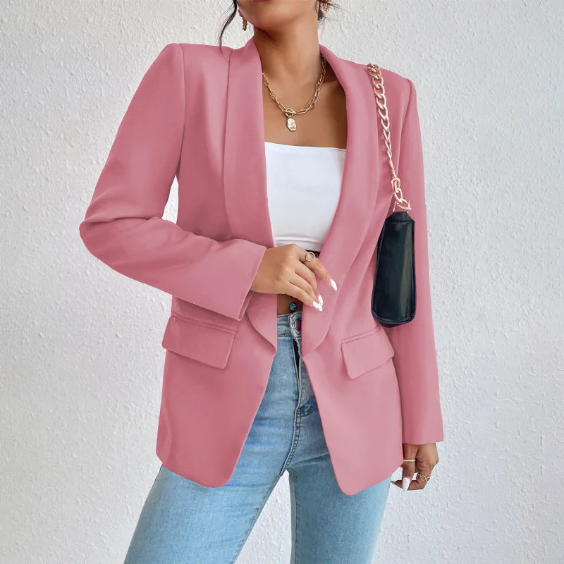 Giacca blazer rosa donna, elegante e moderna, abbinata a top bianco e jeans. Accessorio borsa a catena. Moda femminile casual chic.