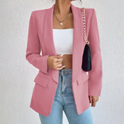 Giacca blazer rosa da donna, elegante e moderna, abbinata a top bianco e jeans. Accessorio: borsa a tracolla nera con catena dorata.