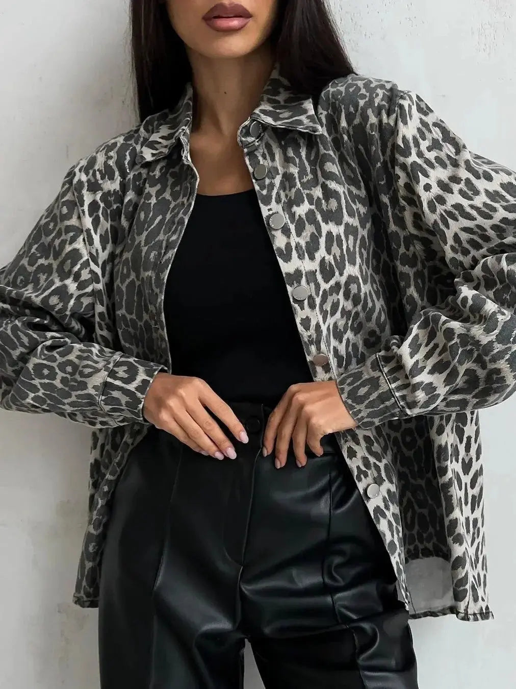 Camicia donna leopardata grigia, abbinata a top nero e pantaloni in pelle nera. Moda femminile, stile casual chic, tendenze abbigliamento 2023.