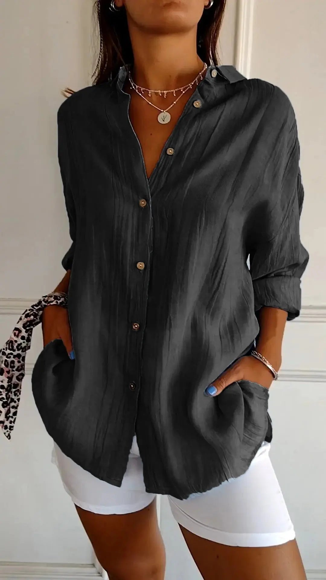 Camicia nera da donna con bottoni, maniche lunghe, tasche, abbinata a pantaloni bianchi. Stile casual elegante, perfetta per moda autunnale.