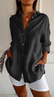 Camicia nera da donna con bottoni, maniche lunghe, tasche, abbinata a pantaloni bianchi. Stile casual elegante, perfetta per moda autunnale.