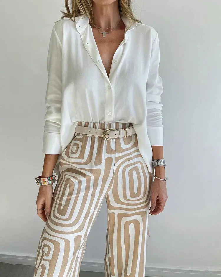 Donna con camicia bianca e pantaloni a fantasia geometrica beige, accessori colorati, orologio argento. Moda casual elegante, stile moderno.