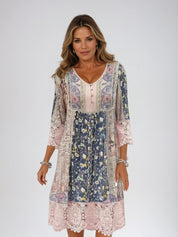 Abito donna boho chic floreale, maniche a 3/4, scollo a V, dettagli in pizzo, colori pastello. Moda femminile elegante e casual.