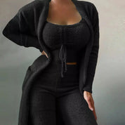 Donna in abbigliamento lounge nero, composto da cardigan, top e pantaloni a vita alta. Moda comoda, tessuto morbido, stile casual chic.