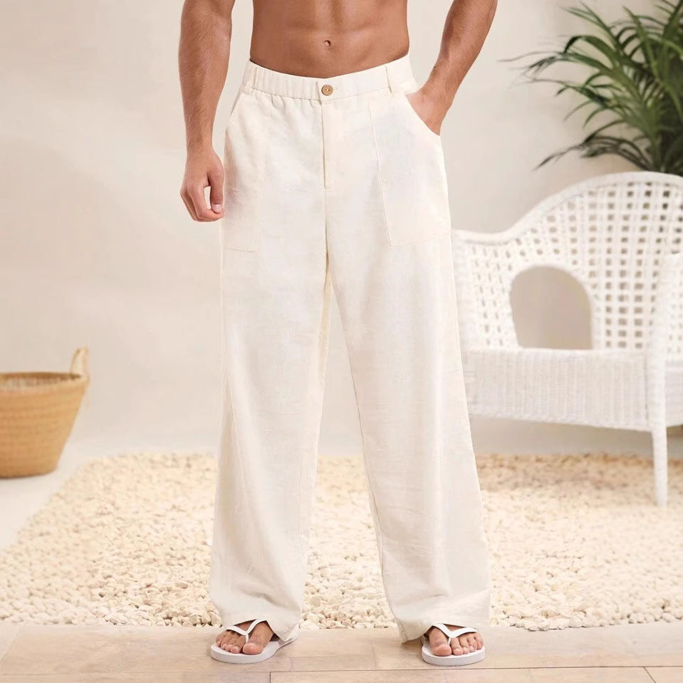 Pantaloni uomo lino bianco, stile casual estivo, con tasche laterali. Perfetti per look rilassato in spiaggia o città. Arredo minimalista sullo sfondo.