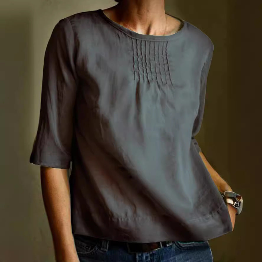 Blusa donna grigia a maniche tre quarti, con dettagli plissettati sul petto. Moda casual elegante, ideale per abbigliamento quotidiano.