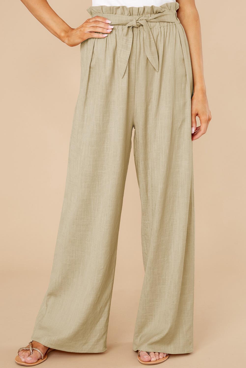 Pantaloni a vita alta beige da donna, con cintura annodata, design ampio e tessuto leggero. Ideali per look estivi eleganti e casual.