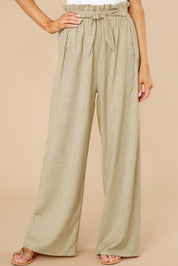 Pantaloni a vita alta beige da donna, con cintura annodata, design ampio e tessuto leggero. Ideali per look estivi eleganti e casual.