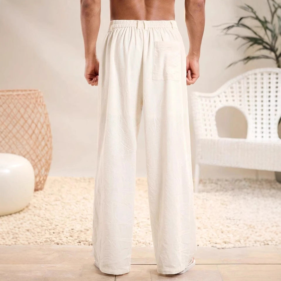 Pantaloni larghi uomo in cotone bianco, vista posteriore, con tasca, stile casual, perfetti per l'estate. Arredamento moderno sullo sfondo.