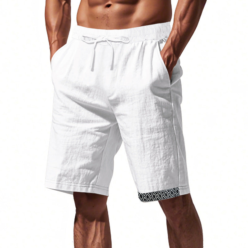 Pantaloncini uomo bianchi in lino, elastico in vita, tasche laterali, dettaglio geometrico nero sull'orlo. Ideali per estate e casual.